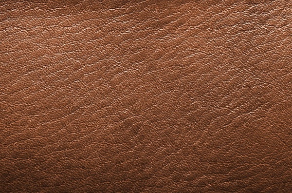 Real vs Fake Leather in Bags-Close - up of brown real Cowhide leather with natural grain texture, emphasizing authentic leather details.