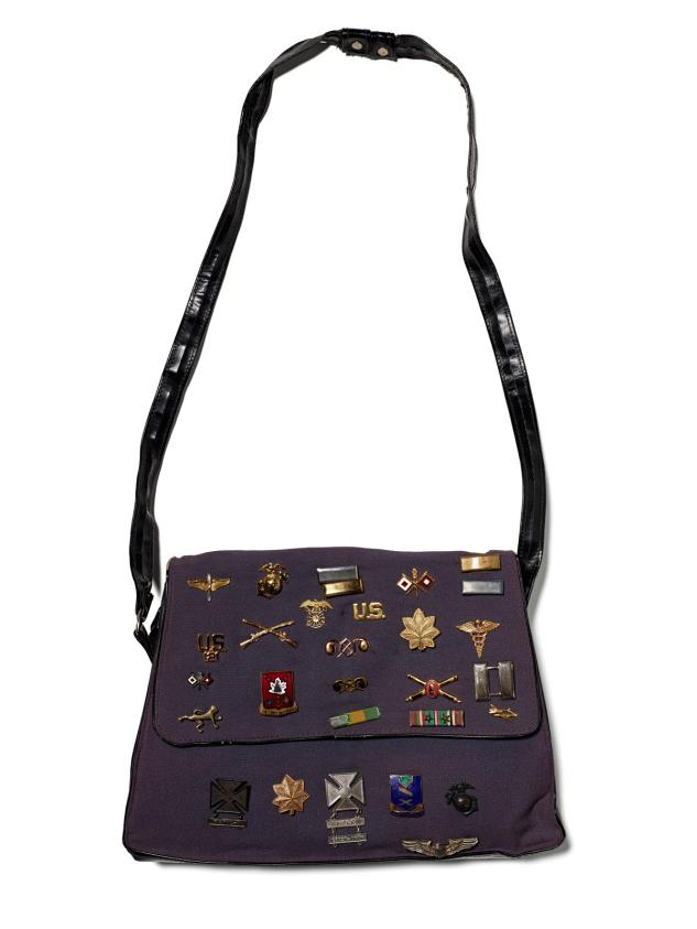 Military-inspired shoulder bag adorned with various US army badges and insignias
