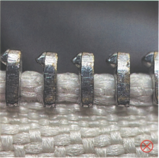 Replica Handbag Store Kelly Bag Replica-Detail of counterfeit Riri zipper on fake Hermès Kelly bag, featuring irregular teeth and poor finishing.