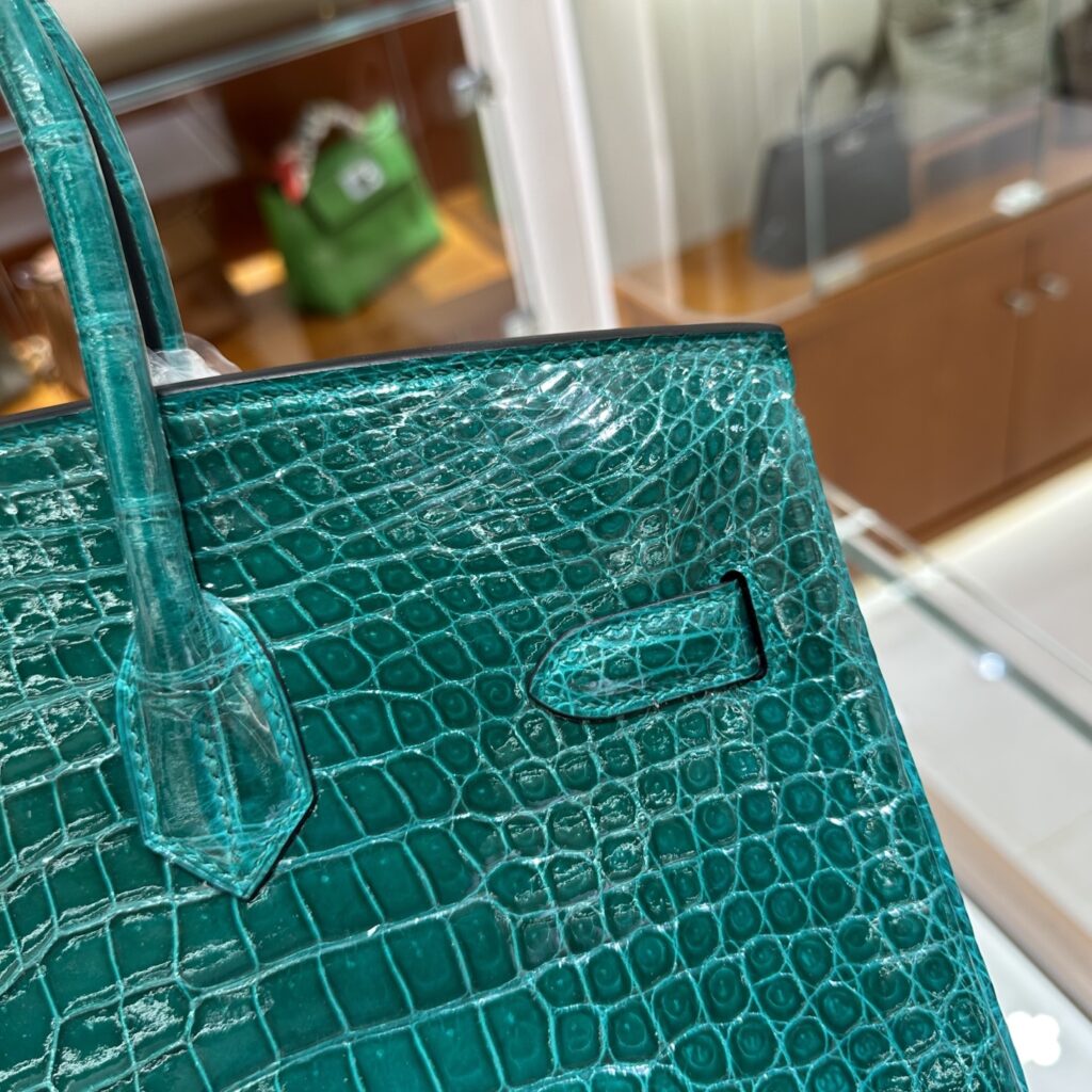 Macro view of authentic Cousu Sellier hand-stitching and symmetrical Porosus crocodile scales on a high-end Replica Handbag Store Birkin replica.