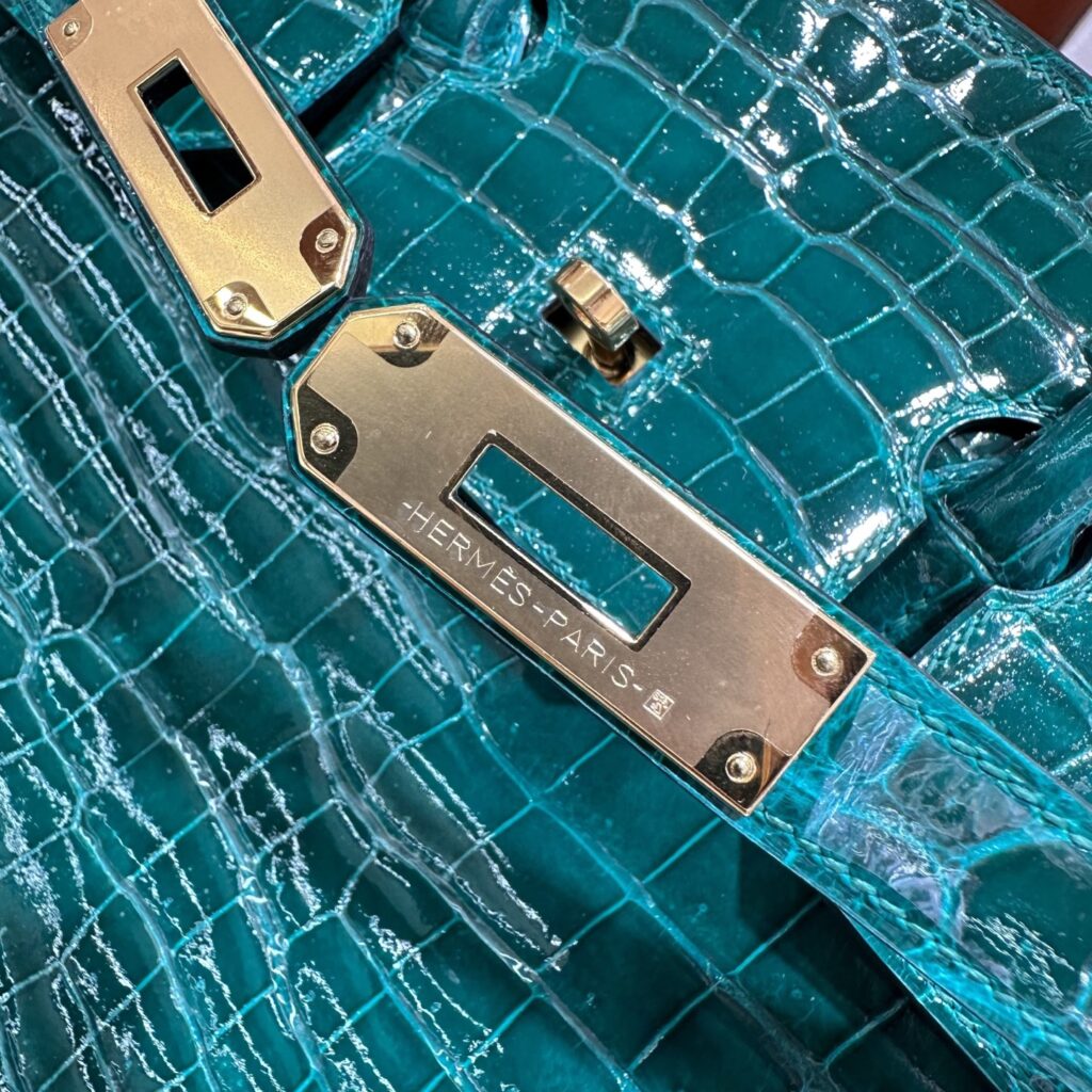 Close-up of the thick 24K gold plated sangle hardware and crisp Replica Handbag Store Paris engraving on a bespoke Birkin 35 replica.