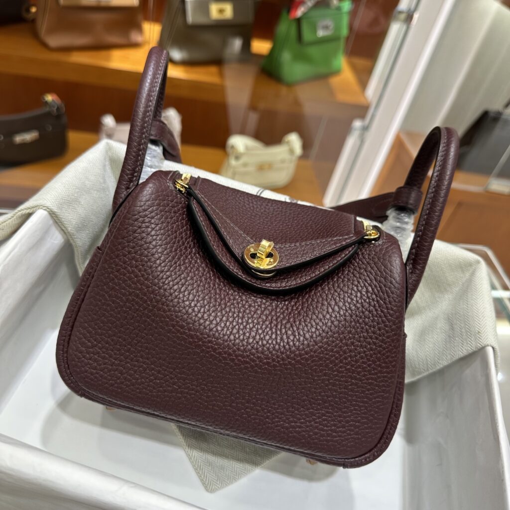 High-quality Replica Handbag Store Mini Lindy 19 replica in Rouge Sellier Clemence leather displaying authentic slouch and gold hardware.