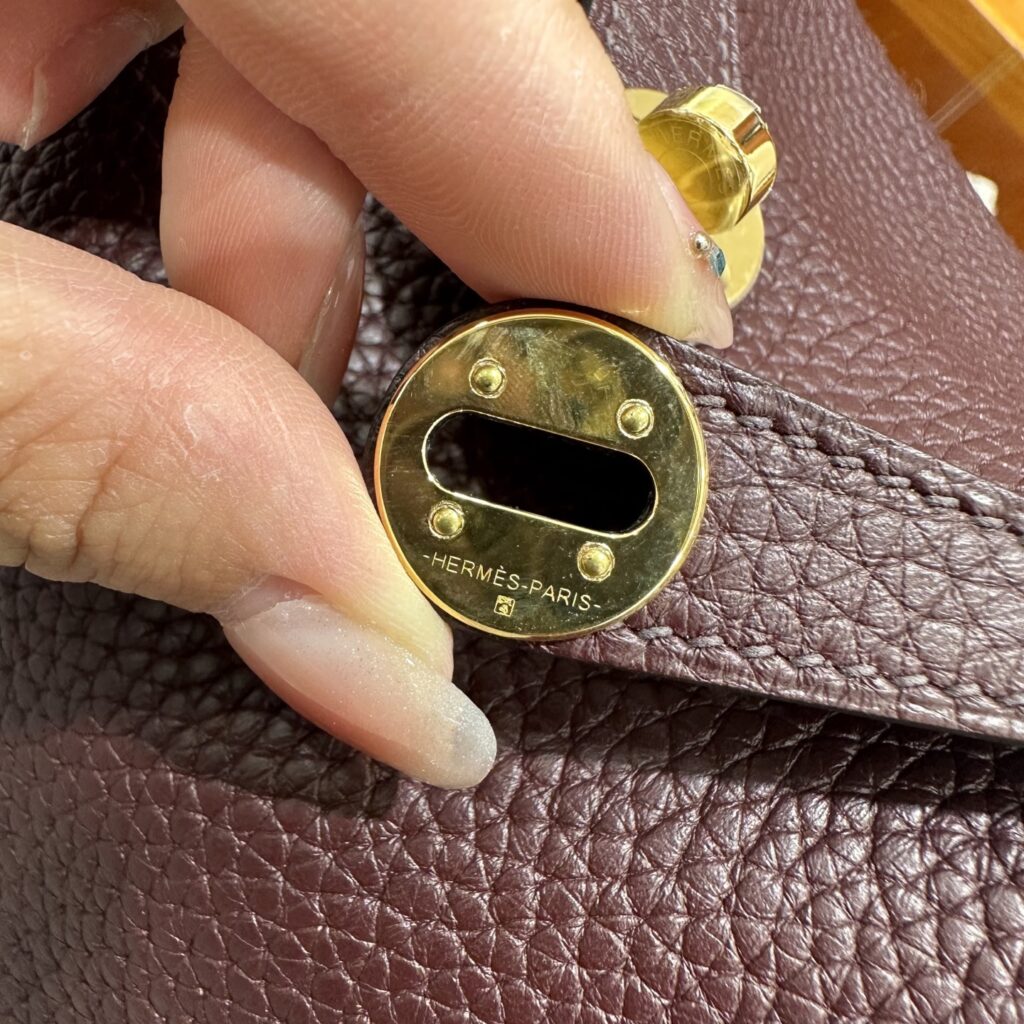 Macro shot of the clean Hermes-Paris hardware engraving and solid stainless steel on a standard handmade Mini Lindy 19 replica.