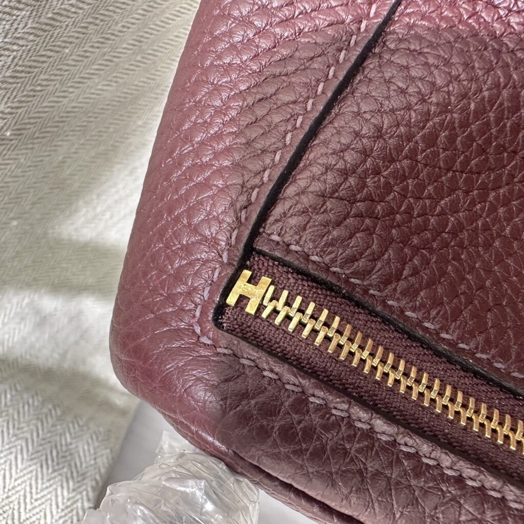 Detailed view of the authentic-style H zipper stop and neat saddle stitching on a Rouge Sellier Replica Handbag Store Mini Lindy replica.