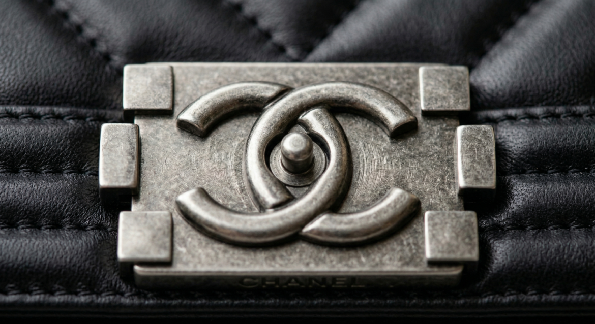 Macro close-up of authentic Chanel modern classic bags front CC lock hardware showing precise wire-drawing polishing marks.